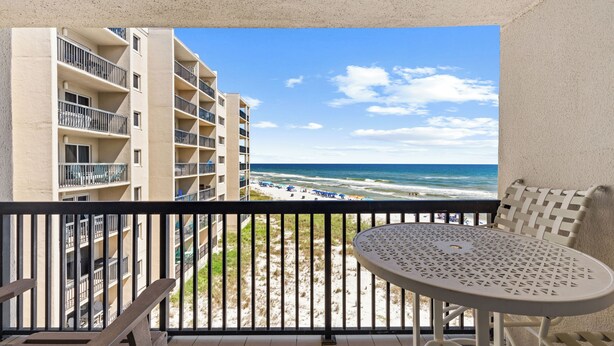A balcony with a view of the beach and ocean, a round table, and a chair. - End of Summer Gulf Views at B2-407 (Panama City Beach)