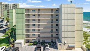 A multi-story hotel with a parking lot, a beach view, and a pool area. - End of Summer Gulf Views at B2-407 (Panama City Beach)