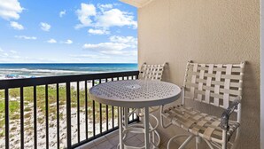 En balkon med udsigt over stranden og havet.