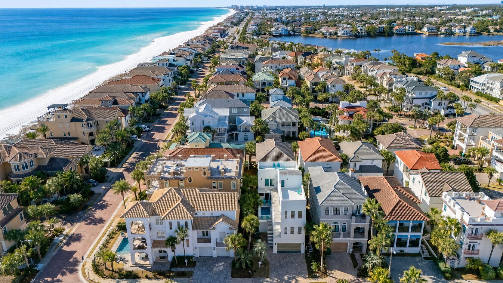 Zona residencial costera con casas, una playa y una extensión de agua.