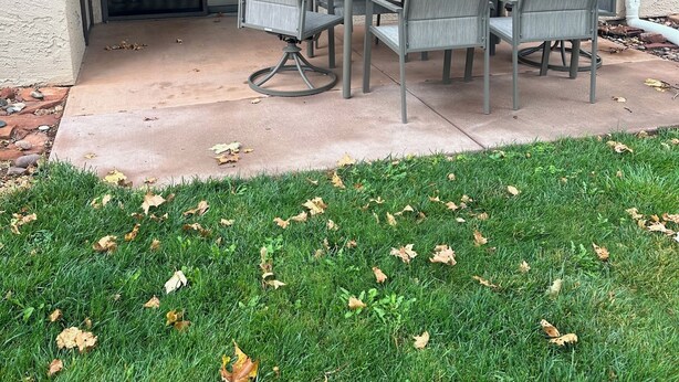 An outdoor patio with a table and chairs, a covered area with a pergola, and a grassy lawn. - Red Rock Memories - Pool / Spa / Pickleball (Sedona)