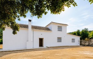 A white building with a tiled roof, a chimney, and a door. - Gorgeous home in Iznajar (Iznajar)