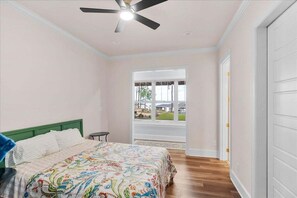 A bedroom with a bed, a window, a ceiling fan, and a door. - Serenity Point | Luxury Waterfront | Excellent Location (Littleton)