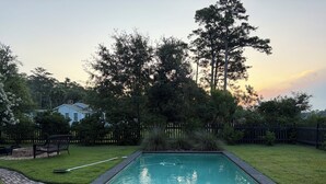 A rectangular swimming pool with a brick pathway leading to it, surrounded by a grassy lawn and a wooden fence. - DEEP WATER DOCK, PRIVATE POOL (Midway)