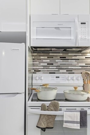A kitchen with a built-in microwave, oven, and stovetop.