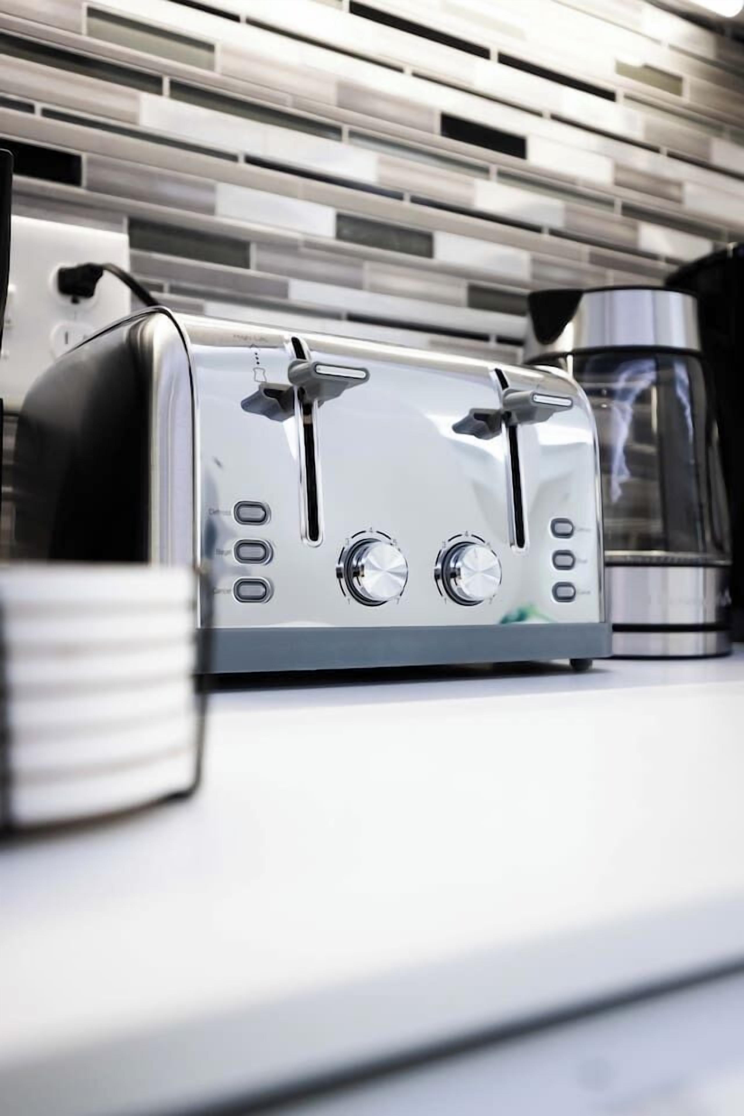 Eine moderne Küche mit einem Edelstahltoaster und einer Kaffeemaschine auf der Arbeitsfläche.