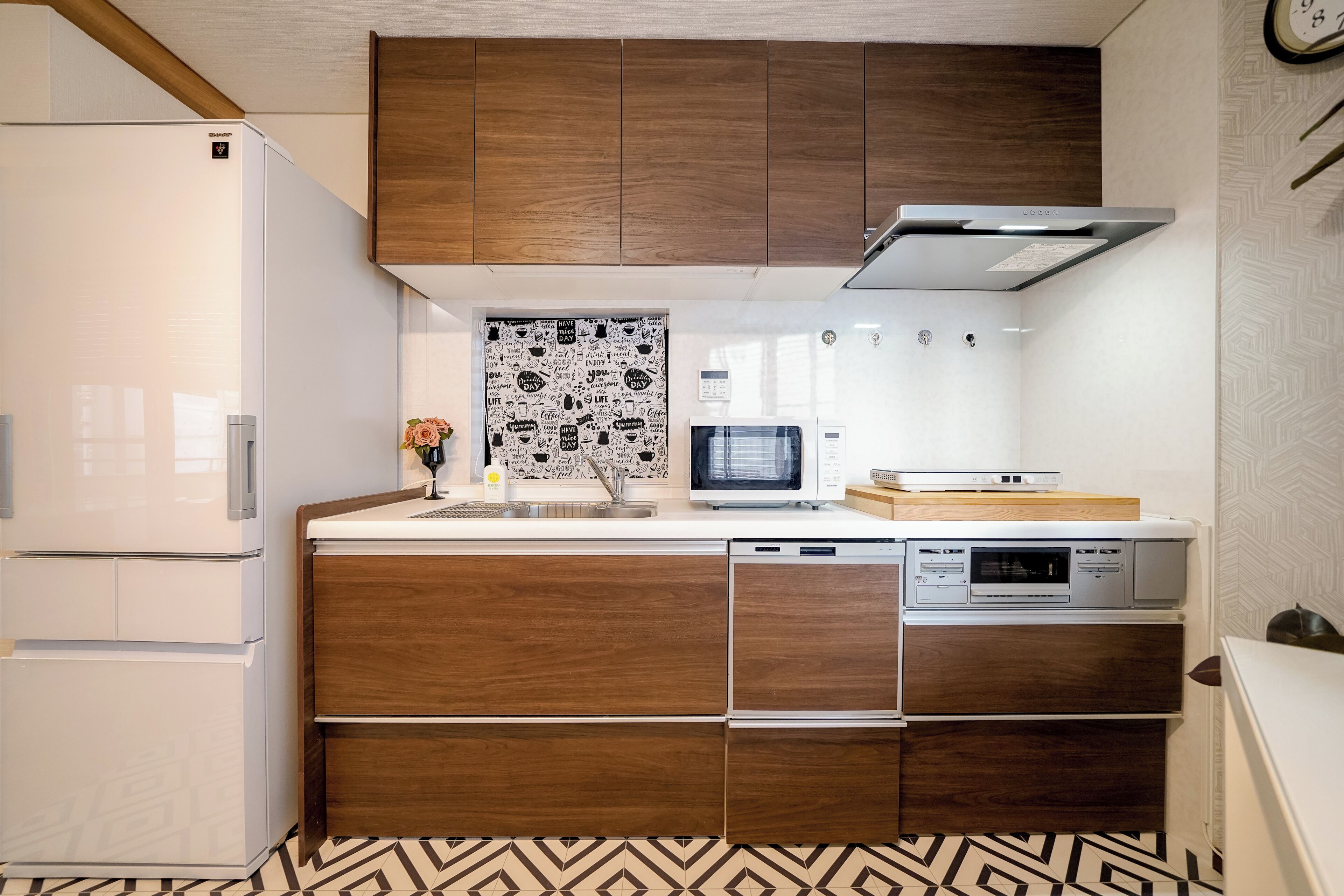 A compact kitchen with a built-in microwave, a dishwasher, and a refrigerator.