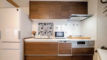 A compact kitchen with a built-in microwave, a dishwasher, and a refrigerator.