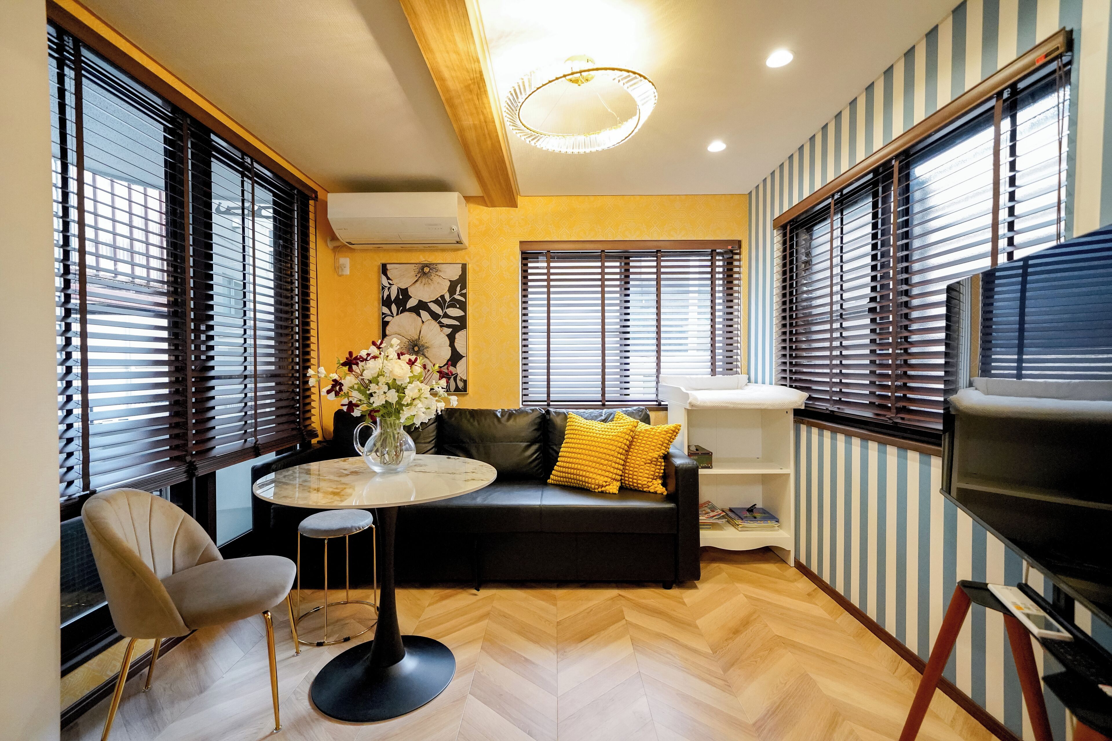 A modern living room with a sofa, a round table, and a TV.