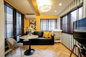 A modern living room with a sofa, a round table, and a TV.