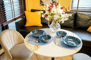 A dining table with blue plates, a vase with flowers, and a chair.