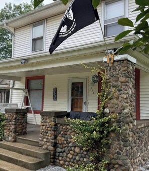 A two-story house with a stone pillar and a flag. - The All-Star Stay (South Bend)