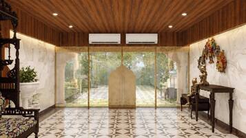 A room with a patterned floor, wooden ceiling, and a view through a glass door leading to an outdoor area.
