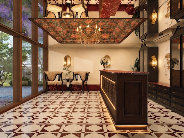 A lobby with a patterned floor, a reception desk, and a chandelier.