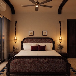 A bedroom with a large bed, a ceiling fan, and two wall-mounted lamps.