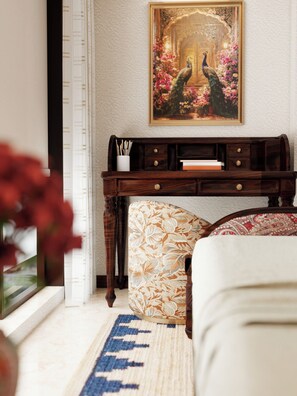 A room with a wooden console table, a patterned ottoman, a framed picture on the wall, and a blue and beige area rug. - Theory9 Luxe - Premium Service Apartments, Pali Hill, Bandra (Bandra West)