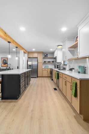 A modern kitchen with wooden cabinets, a central island, and pendant lighting. - Family Retreat with Valley views and 2-Car Garage (Rossville)