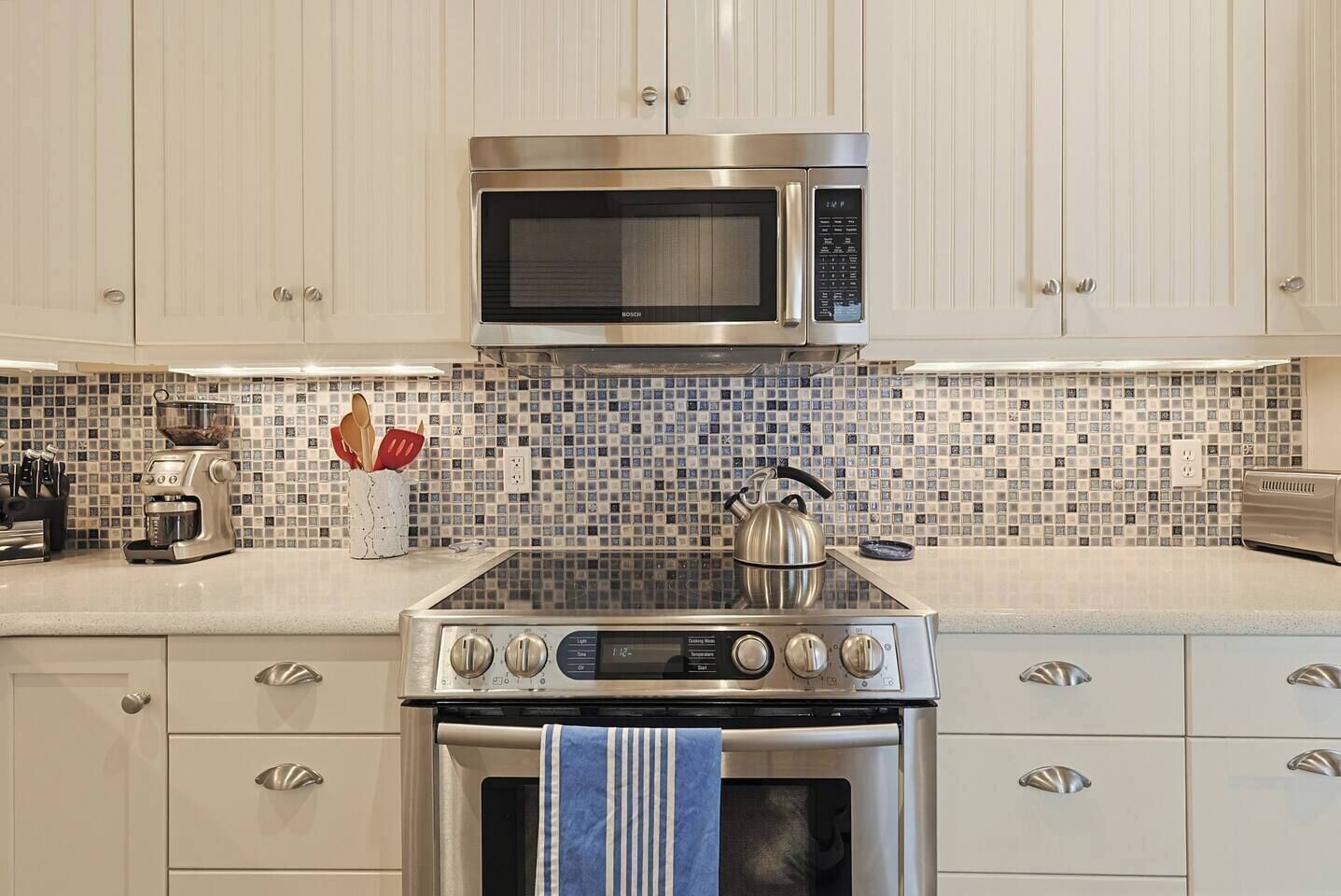 A kitchen with a microwave, stove, and coffee maker.
