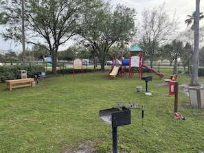 A park with a playground, a bench, and a trash bin. - 2407 New Listing Special ~ Book Sept 7th ~ Pools ~ Gym ~ Onsite Restaurant & Bar (Destin)