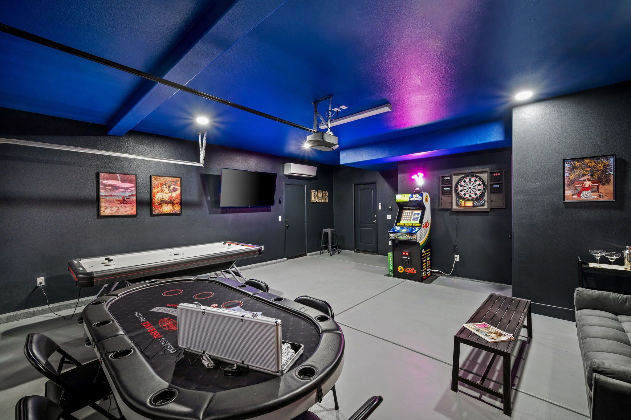 Um quarto com mesa de bilhar, dardos e jogos de fliperama.