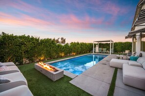 A backyard with a swimming pool, a fire pit, outdoor furniture, and a pergola. - Phoebe by Nest Villas | Private Escape w Game Room (Indio)