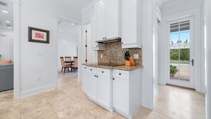 Eine moderne Küche mit weißen Schränken, einer Granitabdeckung und einem eingebauten Backofen.