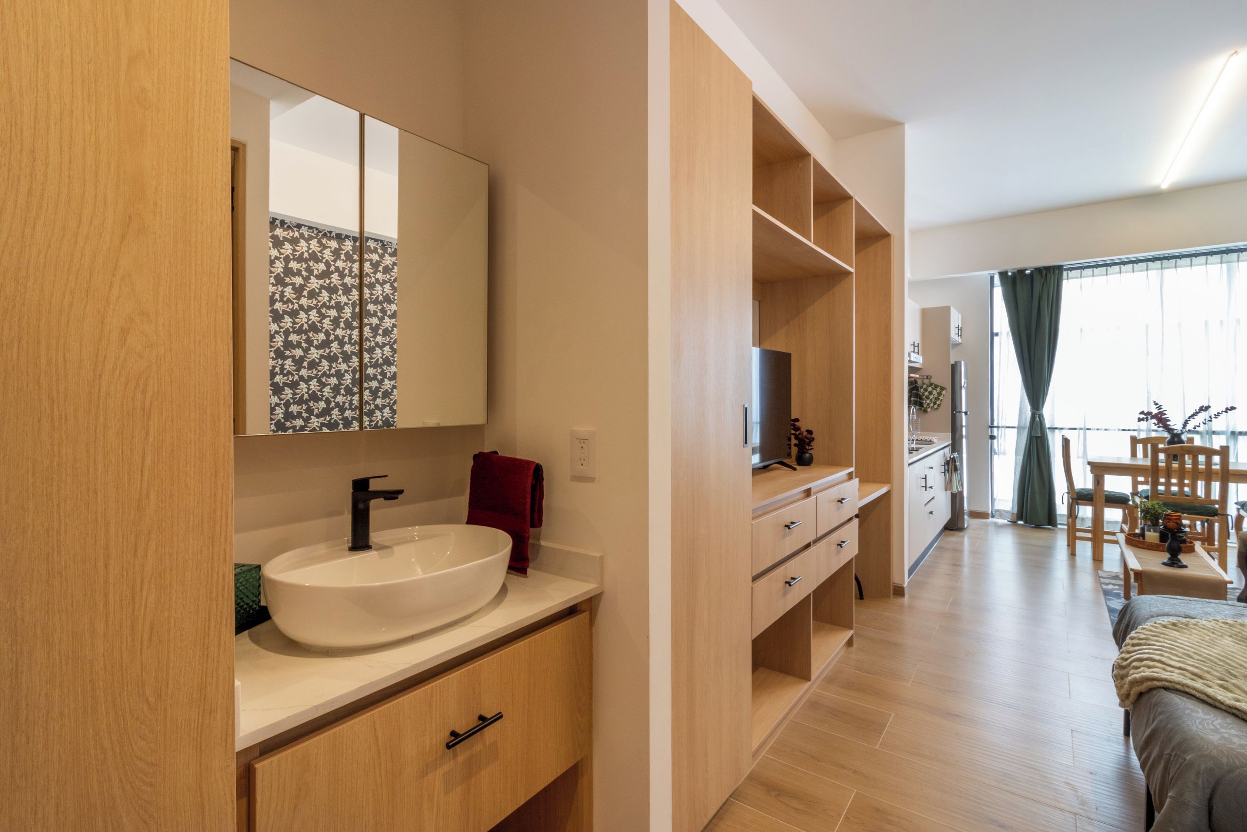 Une salle de bain moderne avec un grand miroir, un lavabo blanc et des meubles en bois.
