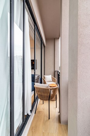 A narrow balcony with wicker furniture and a view of the interior. - Myla Magnolia (Ciudad de México)