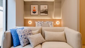A modern living room with a sofa, pillows, and wall art.