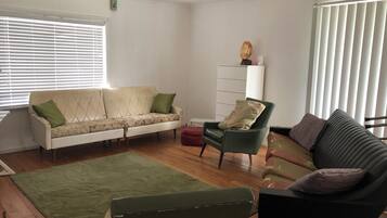 A living room with a sofa, a chair, a small table, and a cabinet.