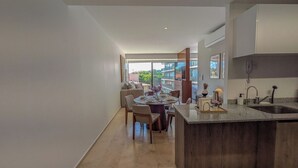 A modern kitchen with a dining area, large windows, and a view of buildings. - Mr. W | Bright and Modern 1-Bedroom | Zentral Tower (Zapopan)