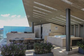An outdoor terrace with a seating area, a pool, and potted plants. - Mr. W | Bright and Modern 1-Bedroom | Zentral Tower (Zapopan)