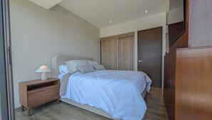 A bedroom with a bed, bedside table, wardrobe, and a mirror. - Mr. W | Bright and Modern 1-Bedroom | Zentral Tower (Zapopan)