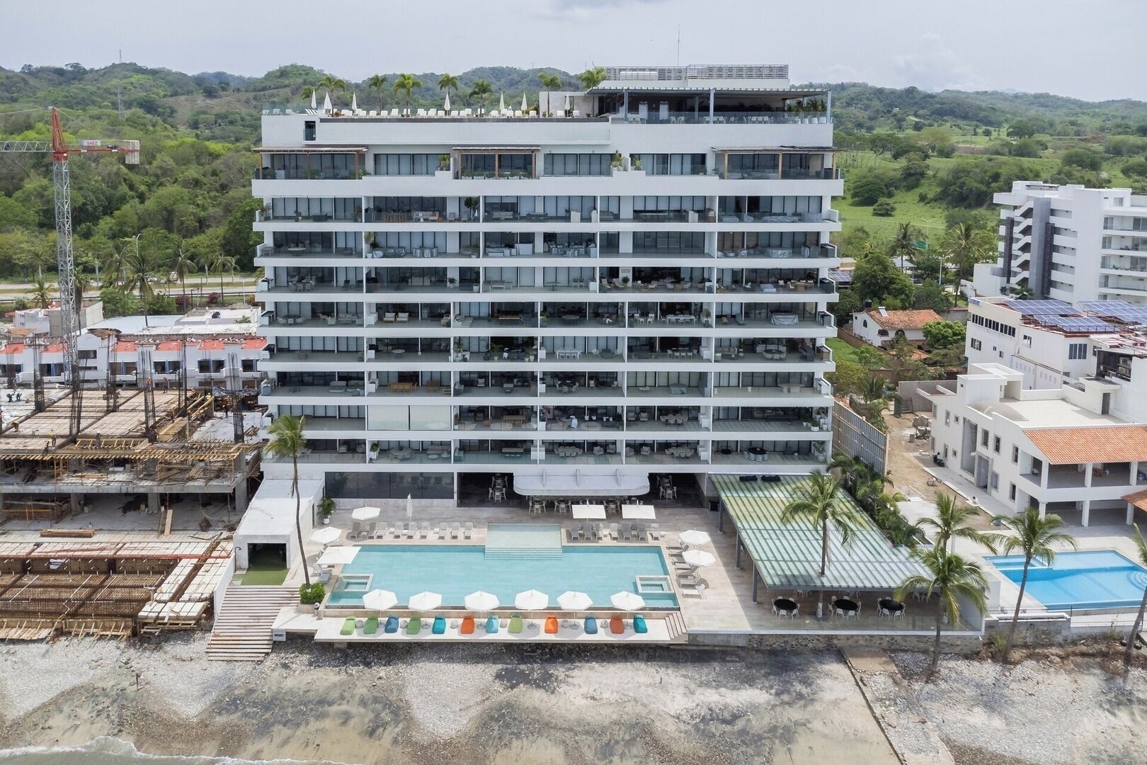 Un hôtel à plusieurs étages doté de balcons, d’une piscine et offrant une vue sur le paysage environnant.