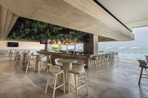 A bar area with wicker furniture and a view of the sea. - Mr. W | Stunning 3-Bedroom Apartment in Bantay | Bucerías (Bucerías)