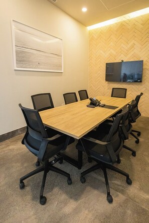 A conference room with a long table, six chairs, a mounted flat-screen TV, and a framed artwork on the wall. - Mr. W | Stunning 3-Bedroom Apartment in Bantay | Bucerías (Bucerías)