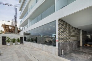 A modern building with a glass facade, a patterned wall, and a tiled courtyard. - Mr. W | Stunning 3-Bedroom Apartment in Bantay | Bucerías (Bucerías)
