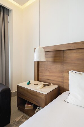 A hotel room with a wooden headboard, a white bed, a bedside table with a green soap dispenser, and a hanging pendant light. - Mr. W | Stunning 3-Bedroom Apartment in Bantay | Bucerías (Bucerías)