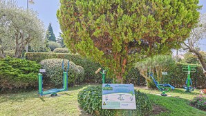 A park with exercise equipment, a sign, and well-maintained greenery. - Upstays Cosy Studio 15m² with pool and quiet (Cannes)