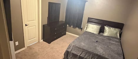 Ein Schlafzimmer mit Bett, Schminktisch und Deckenventilator.