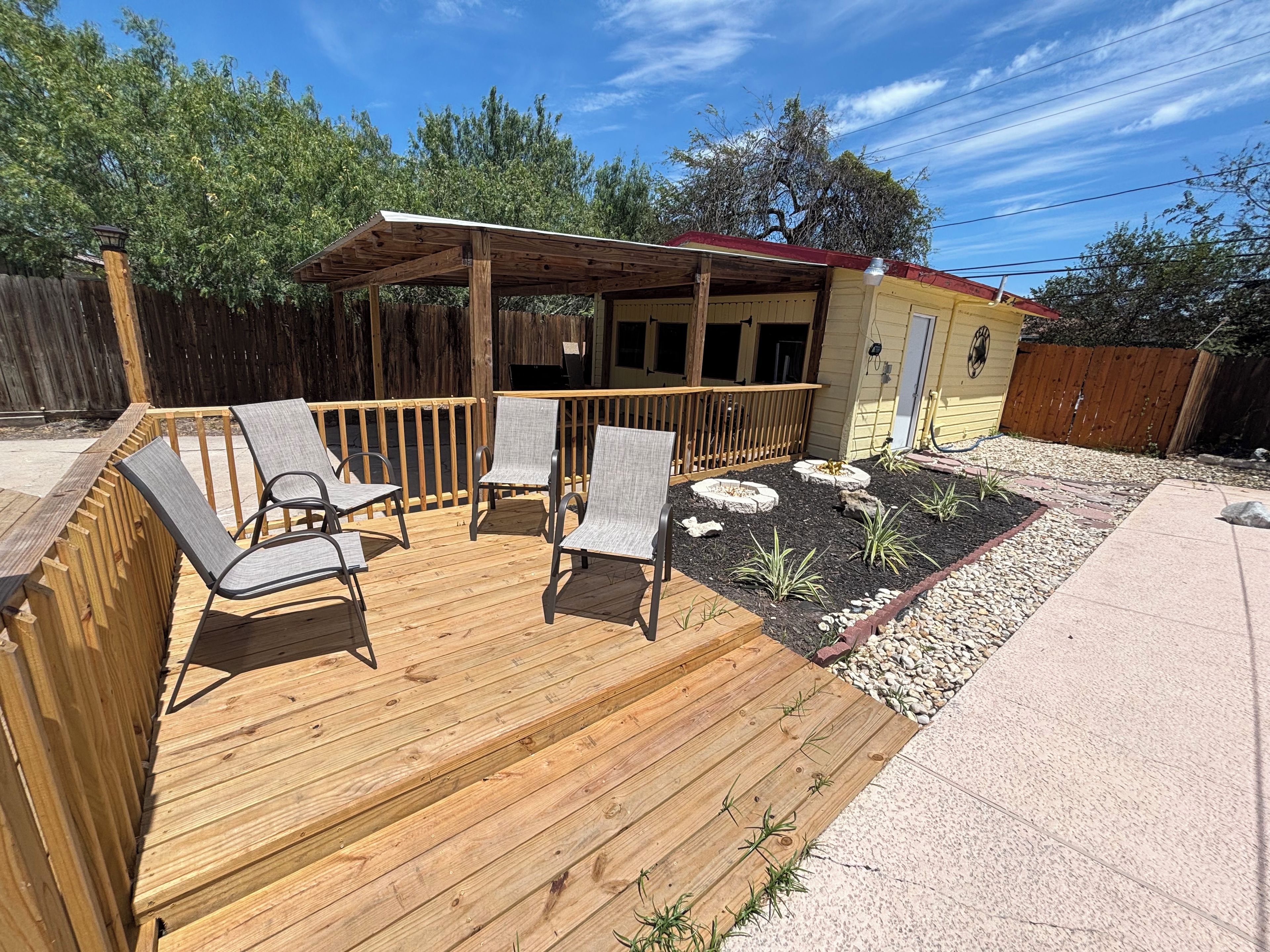 A wooden deck with outdoor seating and a covered area.