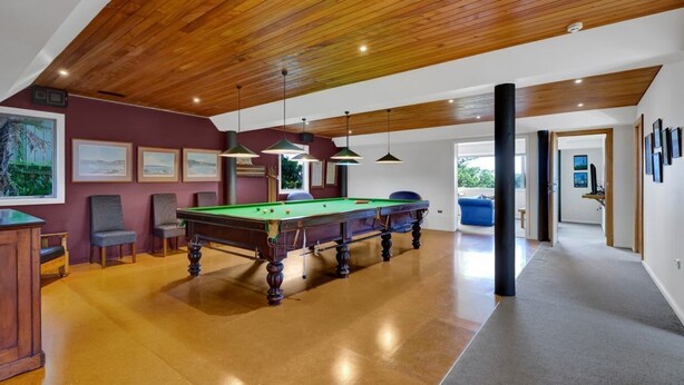 A spacious indoor area with a pool table, wooden ceiling, and framed artwork on the walls. - Views on Devon West - New Plymouth (New Plymouth)