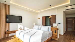 Ein modernes Schlafzimmer mit einem hölzernen Bett, einem Flachbildfernseher an der Wand und einem Holzboden.