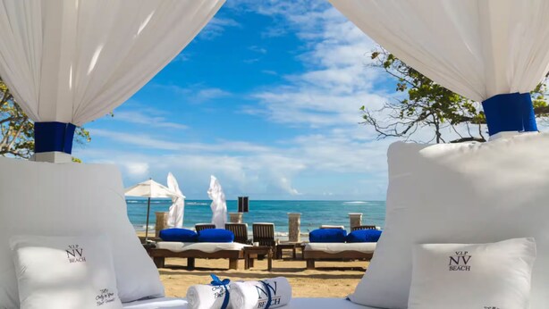 A beachside lounge area with white canopies, blue cushions, and a view of the ocean. - VIP Villa at All-Inclusive Resort 3B (Confresi Beach)