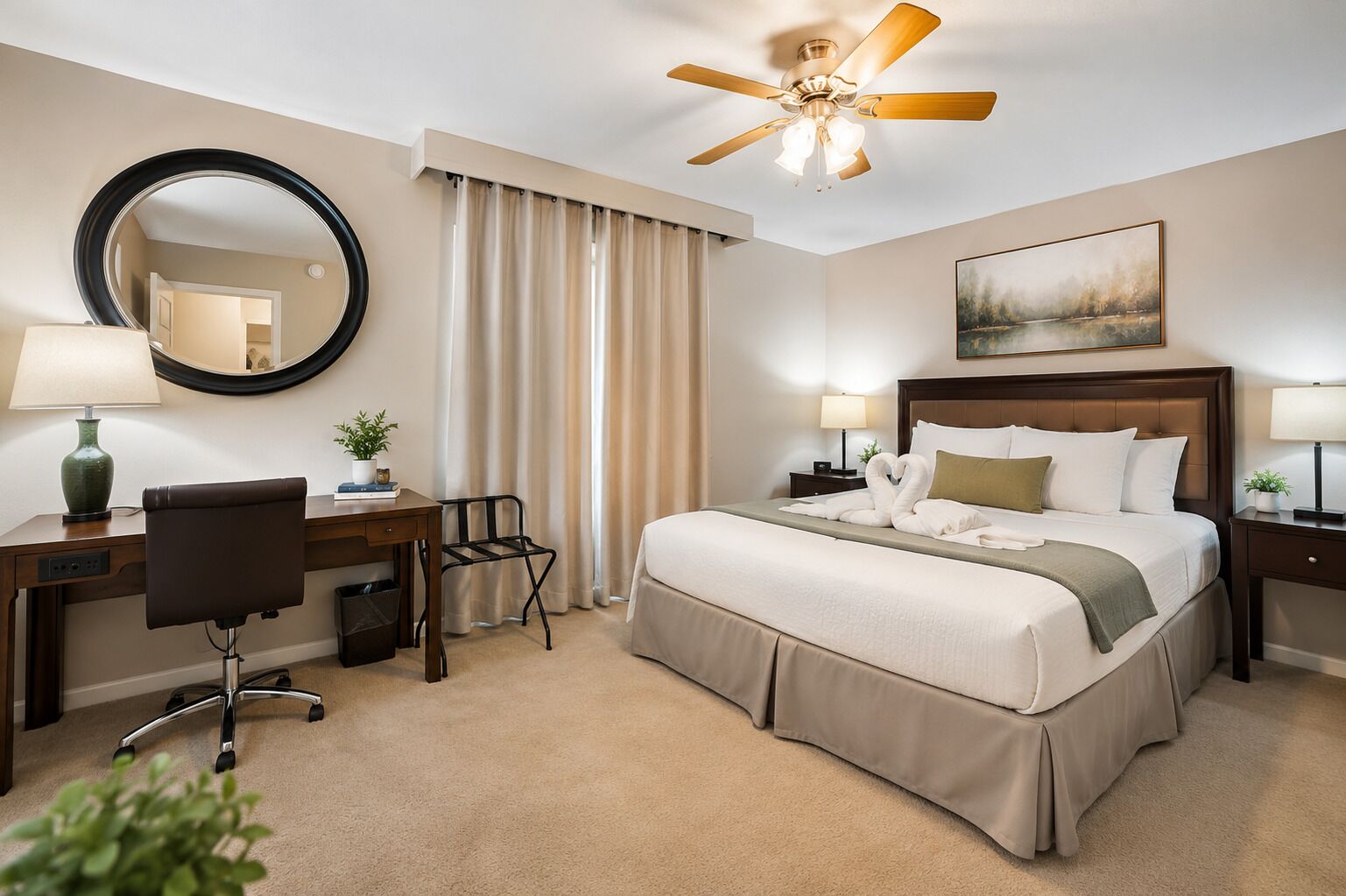 A hotel room with a bed, desk, chair, and a ceiling fan.