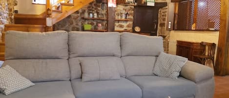 Ein Wohnzimmer mit einer Couch, einem Couchtisch und einer Treppe, die zu einer Bar führt.