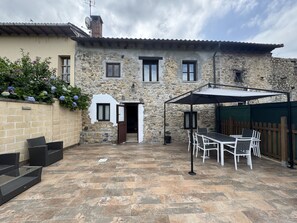 A stone building with a patio area, outdoor seating, and a covered table. - El Valle de la Reina House VV-4003-AS (Romillo)