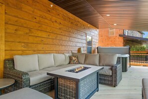 An outdoor seating area with a sofa, a table with a fire feature, and a grill. - Cozy Tall Timbers Retreat_Pvt Hot Tub_Near Lazy River_Free Tickets_Shuffleboard_Arcade (Hollister)