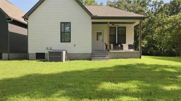 A single-story house with a front porch, a small attached garage, and a well-maintained lawn.
