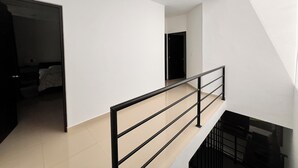 A modern interior with a staircase, a flat ceiling, and a door leading to another room.